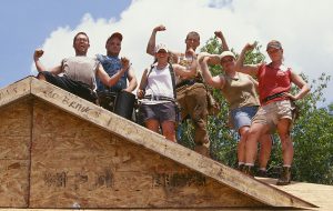 Participants in the Americorps Build-a-Thon pose together on the roof of a Habitat house. (Americorps Build-a-Thon 2002)