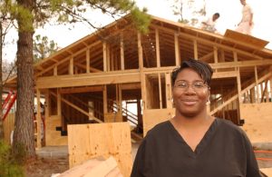 Offenders, members of the InnerChange program at the Carol Vance Unit, building a Habitat house during the Houston Habitat for Humanity "SuperBuild XXXVIII."  Homeowner Ree Randall is pictured in front of her future home. (Prison Partnership 2004)