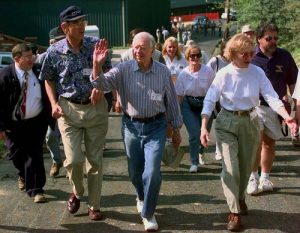 Former President Jimmy Carter waves to friends as he walks to one of the sites of this year's Habitat for Humanity building project, with his wife, Rosalynn, and Millard Fuller, Habitat for Humanity International founder, on Sunday, June 15, 1997, in Pikeville, Ky. Carter and hundreds of others will be building nine houses this week for the needy. (AP Photo/Ed Reinke)