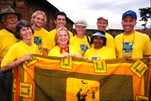 A group of volunteers with a Global Village team hold up a blanket at the 20,000 Houses celebration in Jinja, Uganda. (2001)